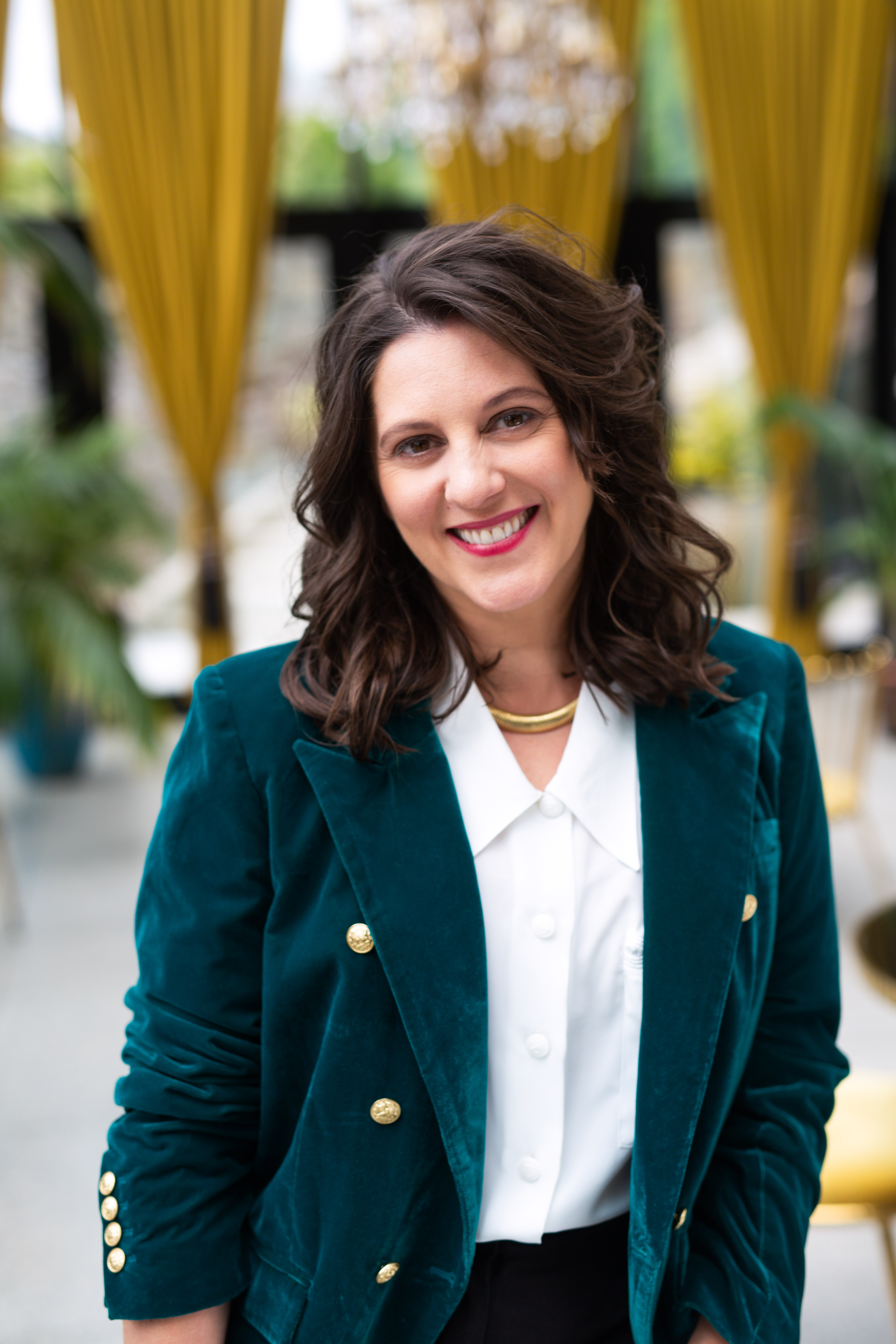 Carly Clark Zimmer smiling in a green velvet jacket