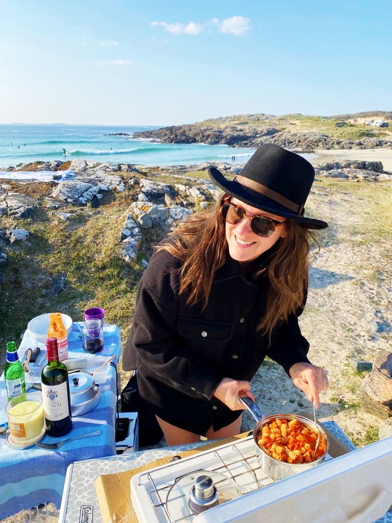 Carly cooking outdoors beside the sea in Connemara, Ireland