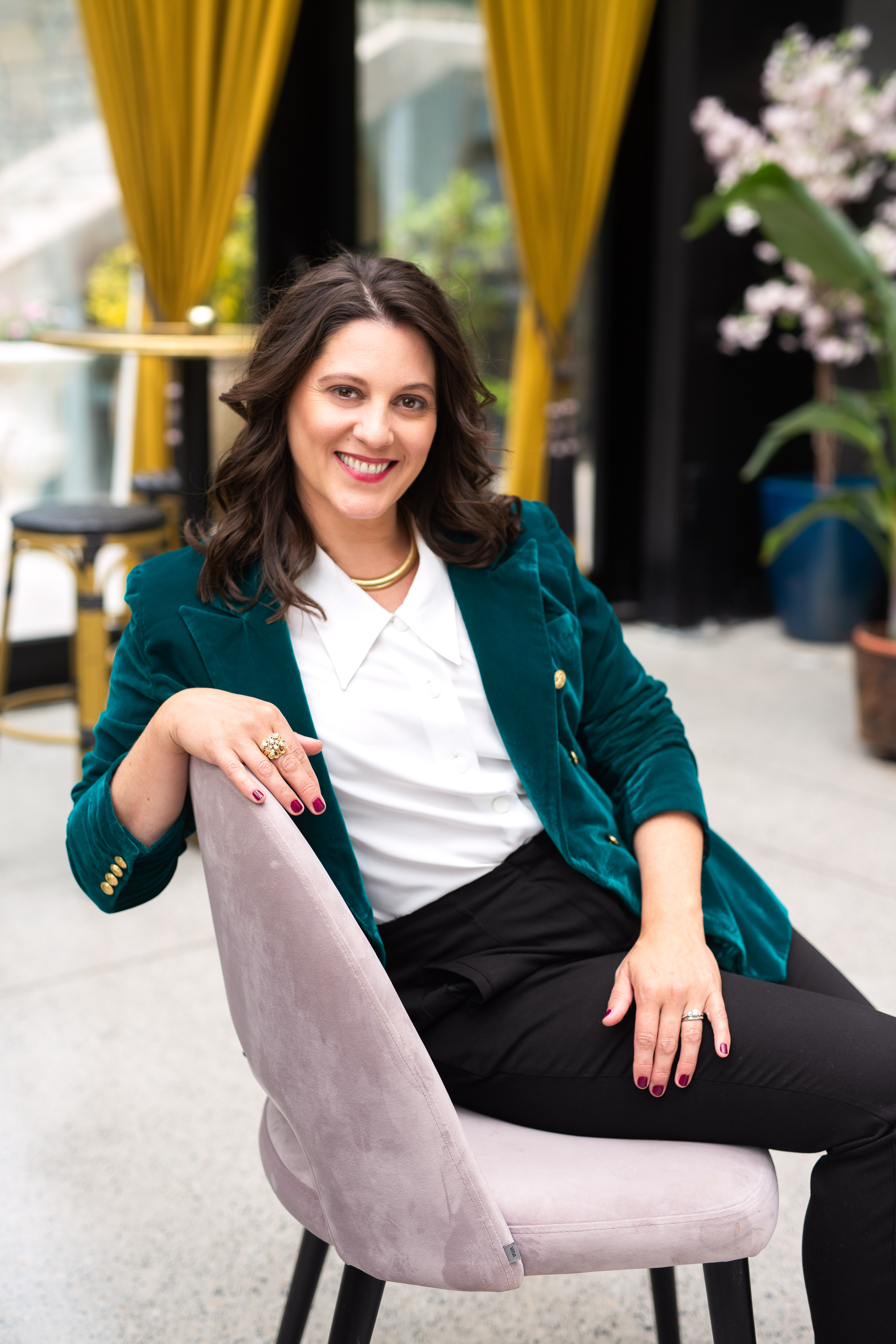 Carly Clark Zimmer seated in a green velvet jacket