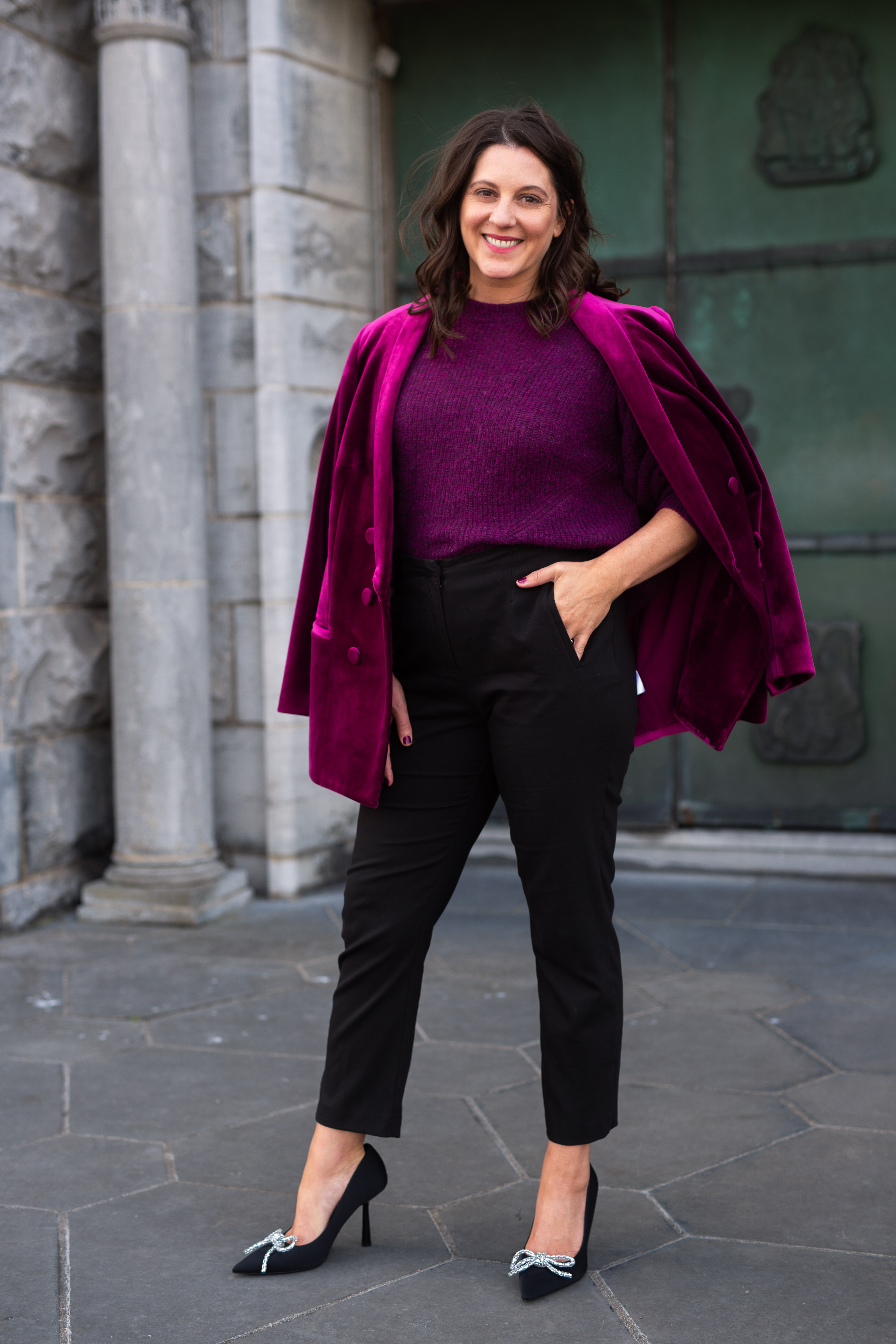 Carly Clark Zimmer smiling in a magenta velvet jacket