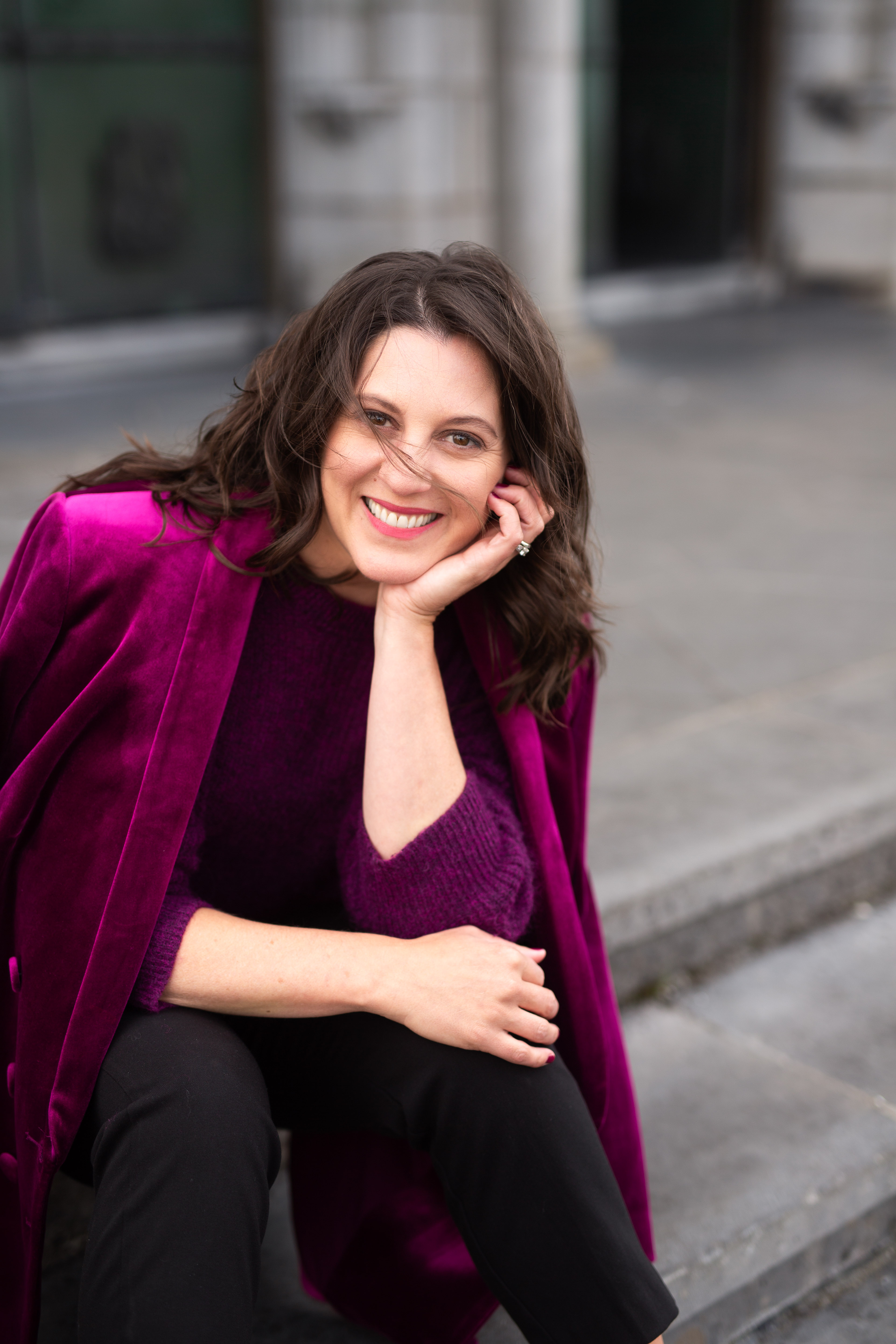 Carly Clark Zimmer smiling in a berry-colored jacket