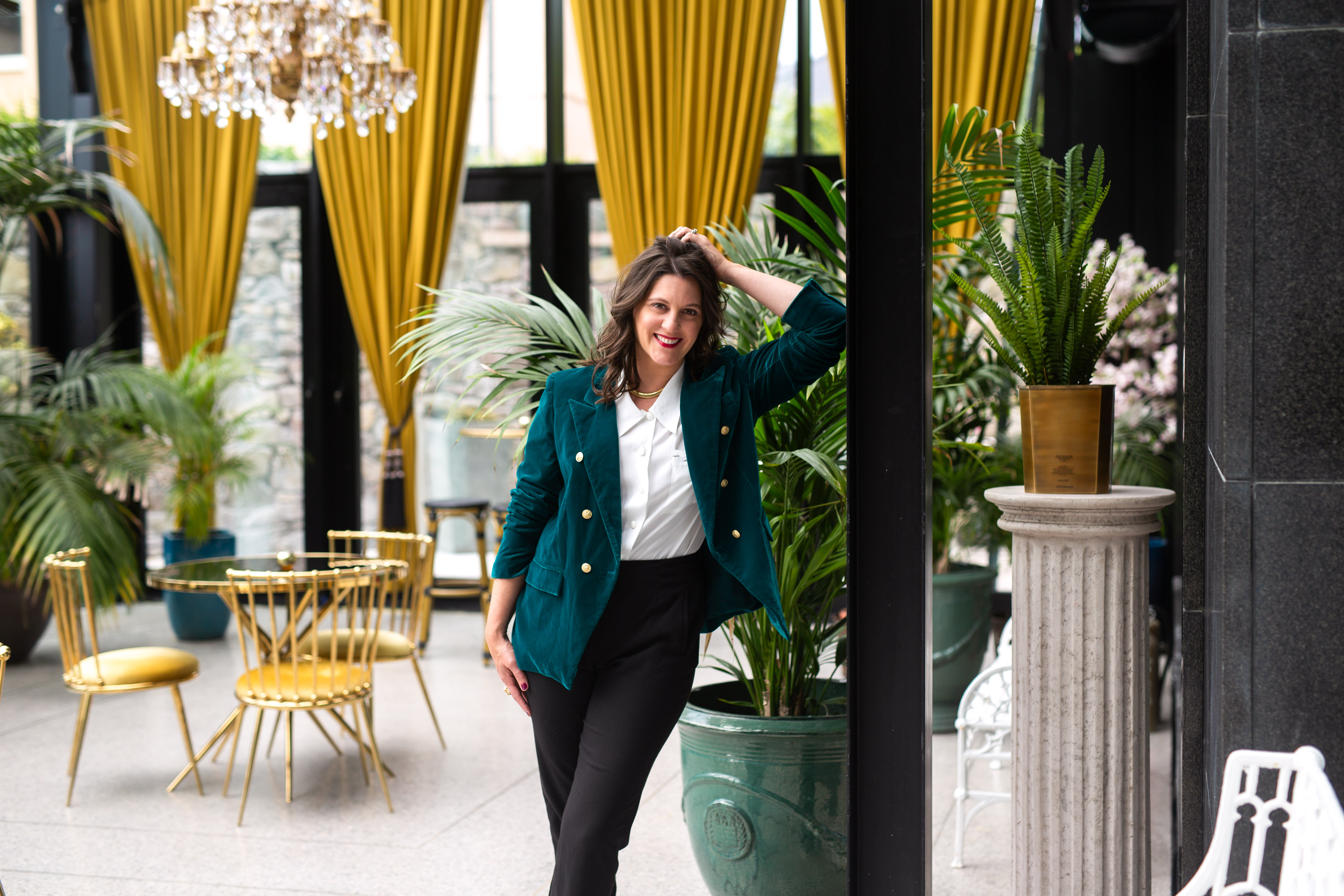 Carly Clark Zimmer standing in an elegant room surrounded by plants
